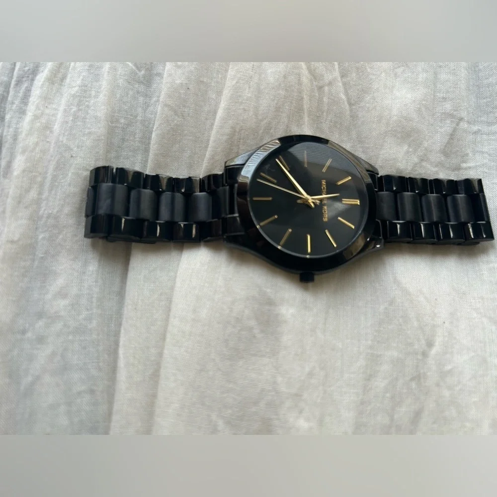 Michael Kors Black and Gold Watch It needs a battery replacement.